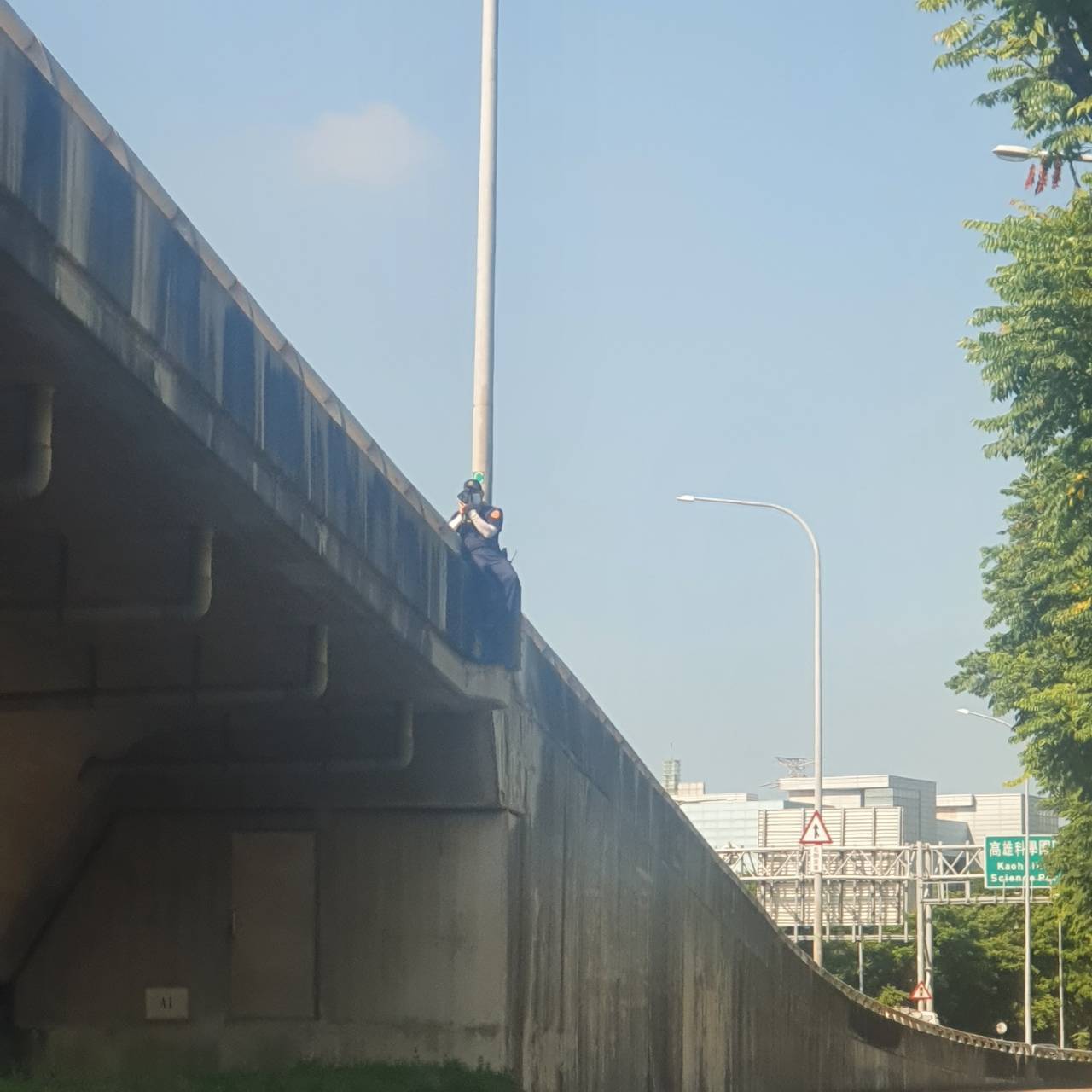 驚！國道警察取締違規 竟爬出護欄外？