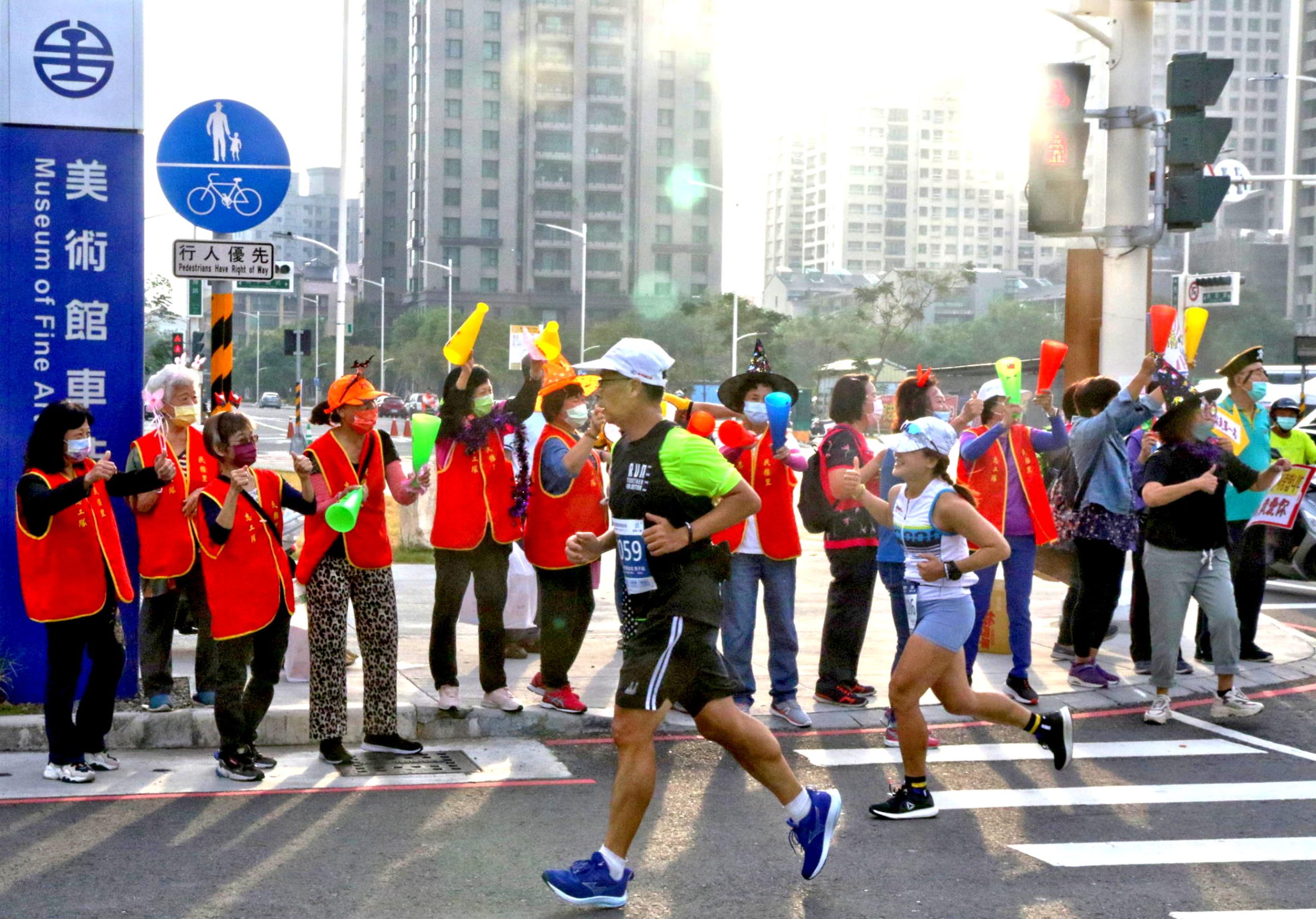 高雄富邦馬拉松邀請市民一同支持活動，禮讓選手通過，並為跑者加油！ （運發局提供）