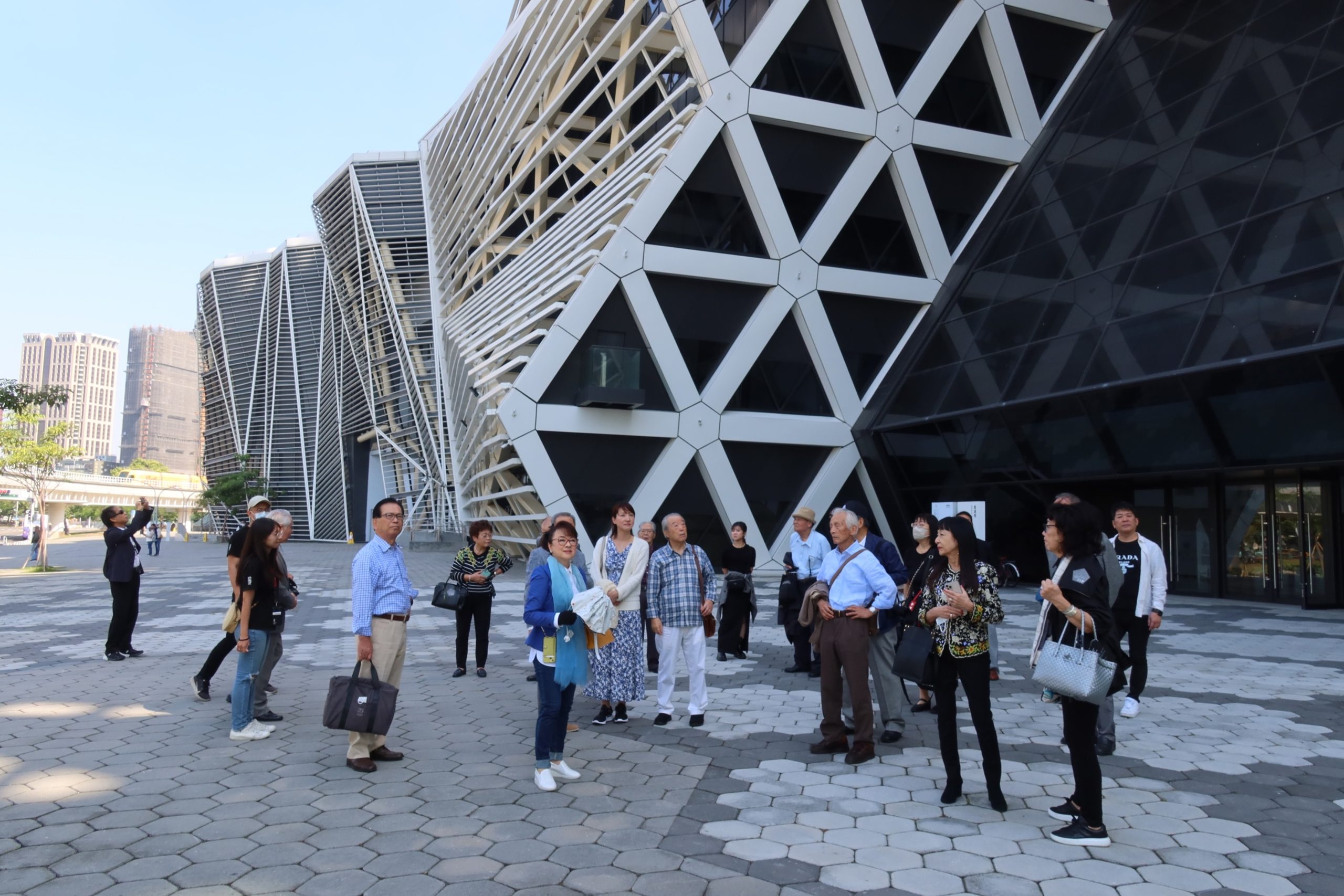 翁倩玉與日本友人在音浪塔外聆聽建築師翁祖模的導覽 。（高流提供）