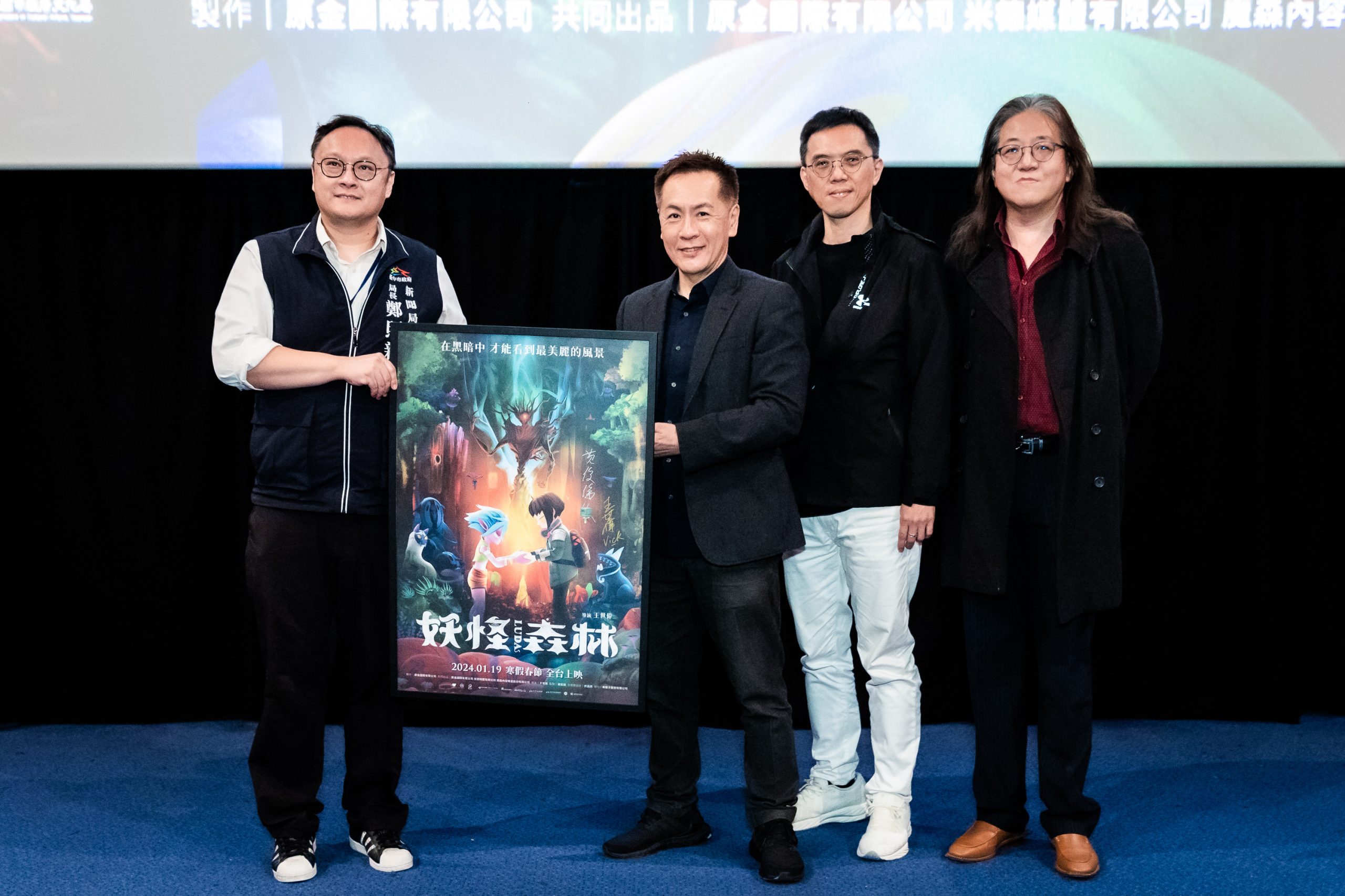 《妖怪森林》台中首映導演王世偉（左二至左四）、監製黃俊傑及聲音統籌胡育彰，致贈電影簽名海報給新聞局長鄭照新（左一）。（新聞局提供）